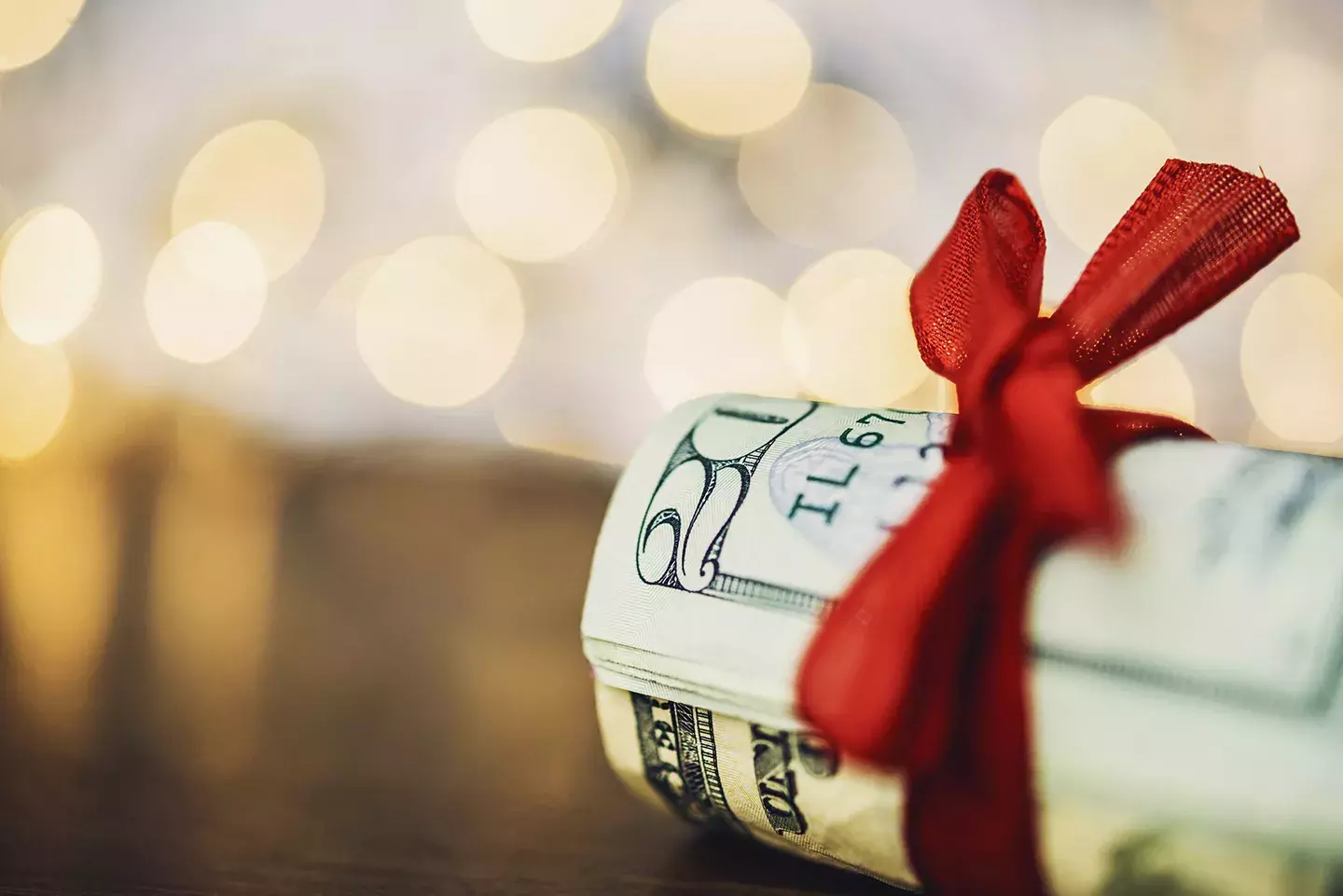 Wad of cash wrapped in red ribbon