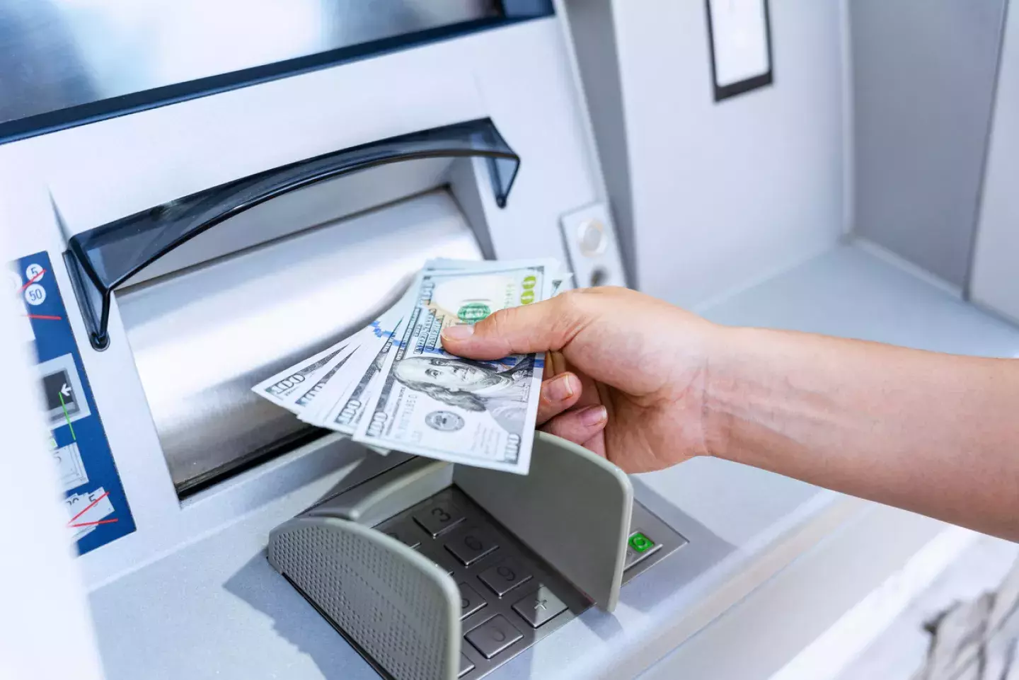 Person receiving money from ATM machine